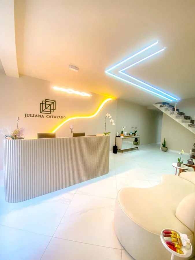 Recepção da clínica, com a iluminação em fita e a escada ao fundo