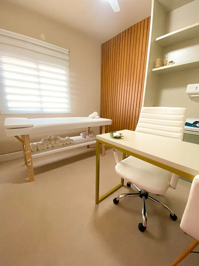 Sala de atendimento com maca e painel ripado de madeira