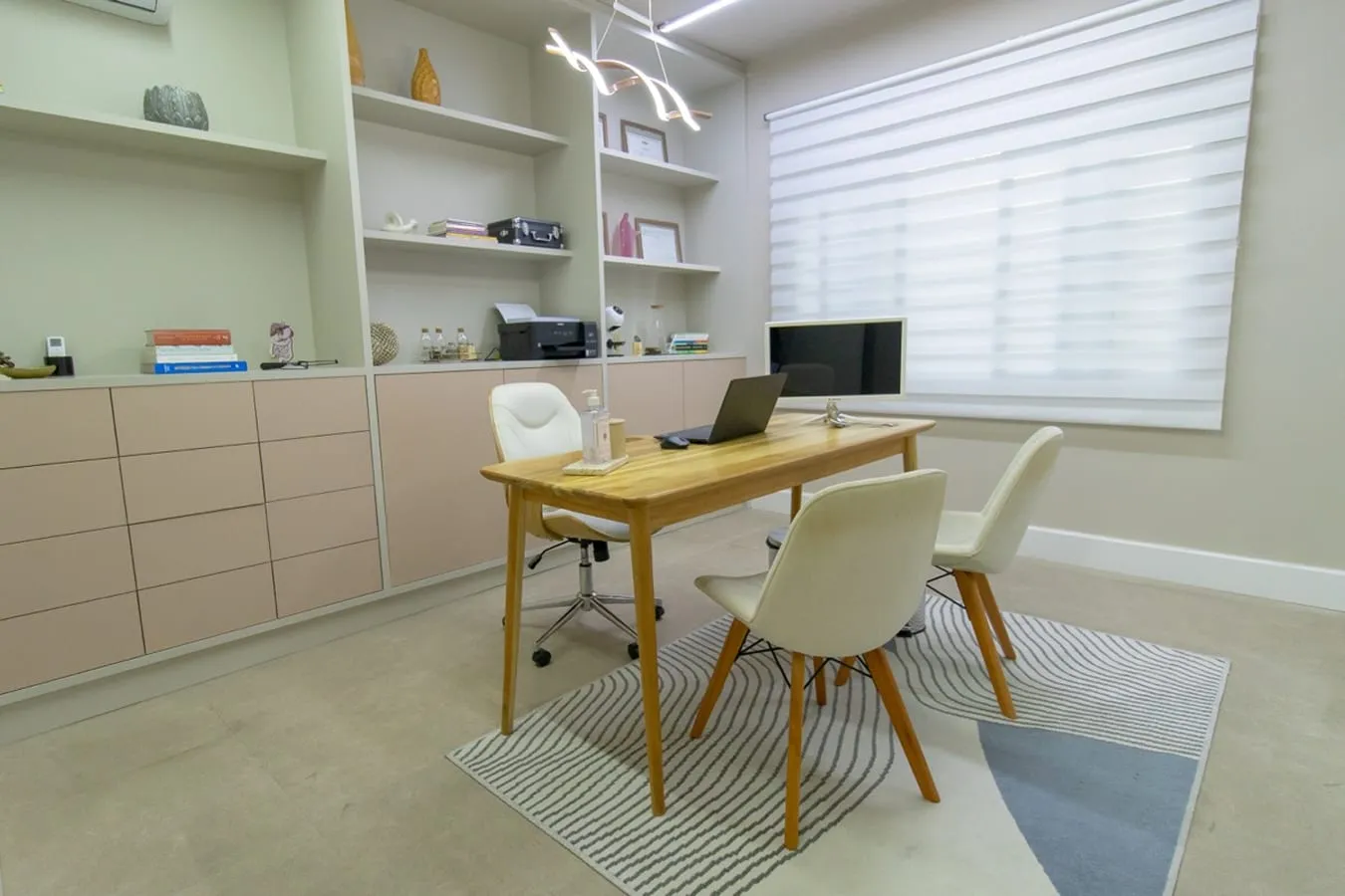 Consultório com mesa de atendimento e armários