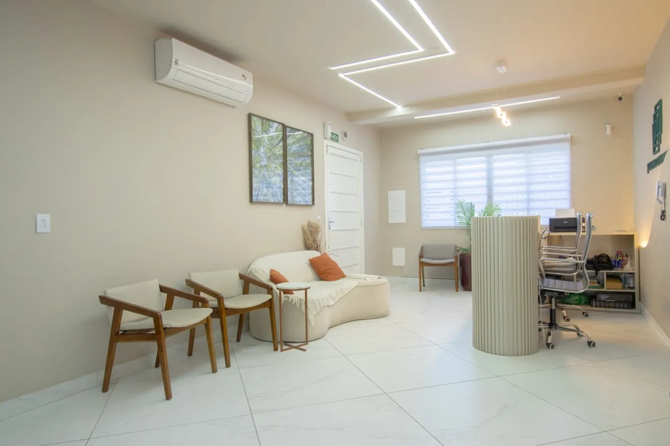 Sala de espera com poltronas e mesa de apoio
