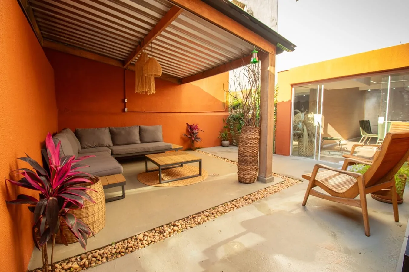 Área externa de descanso, com sofá e plantas